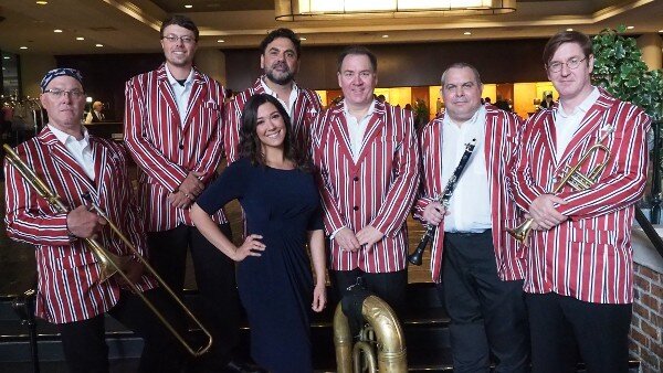 The Assunto Dukes (from left): Alex Holmes, trombone; Scott Kyser, keyboards; Marc Joseph, drums; Jim Syoen (co-leader), tuba; Ryan Burrage (co-leader), clarinet; Jim Thornton, trumpet; (in front) Lexie Assunto (Frank Assunto’s granddaughter), vocals. (Photo Credit: Armand “Sheik” Richardson)